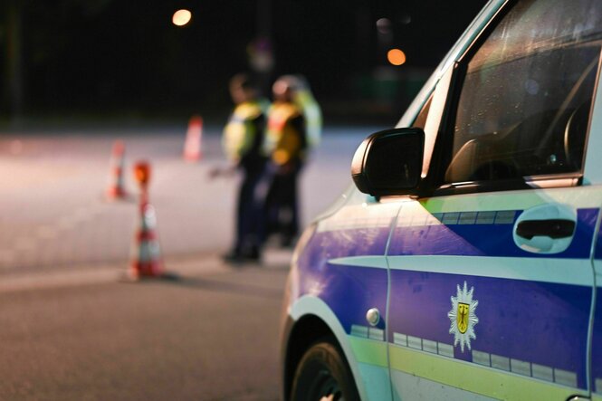 Ein Polizeiauto im Vordergrund und Beamte der Bundespolizei unscharf im Hintergrund