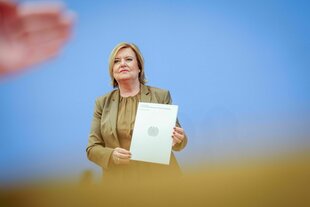 Eva Högl hält ein Dokument, auf dem der Bundesadler abgebildet ist, in den Händen