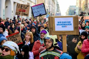 Protestaktion auf der Straße - die Protestierenden halten Schilder hoch 