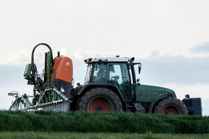 Landwirt bringt mit seinem Traktor Pflanzenschutzmittel auf das Feld aus