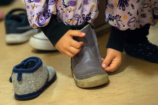 Kind beim Anziehen von Schuhen