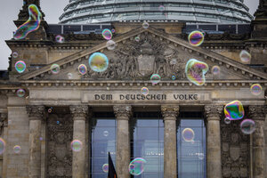 Große Seifenblasen schweben vor dem Reichstagsgebäude