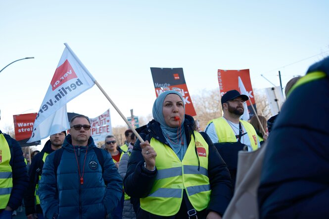 Eine CFM-Mitarbeiterin mit Verdi-Flagge in der Hand auf einer Streikdemo