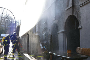 Einsatzkräfte der Feuerwehr löschen einen Brand in einem Harburger Theater