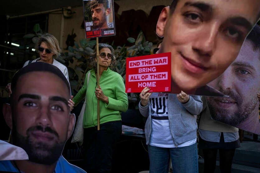 Demonstranten halten Schilder mit Gesichtern hoch