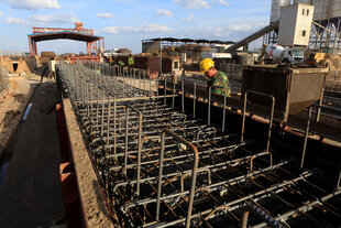 Bau einer Bahnstrecke in Nairobi, ein Arbeiter schaut sich die Stahlträger an