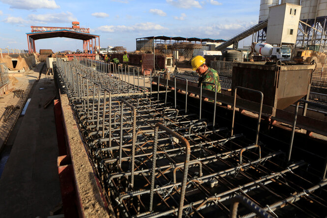 Bau einer Bahnstrecke in Nairobi, ein Arbeiter schaut sich die Stahlträger an