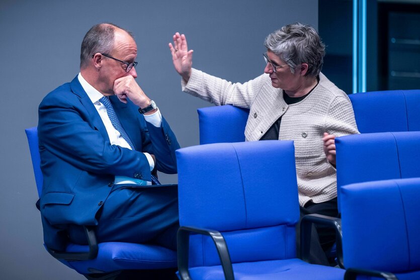 Britta Haßelmann und Friedrich Merz sitzen nebeneinander und unterhalten sich