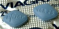 Zwei Viagra-Tabletten liegen auf der Medikamentenverpackung