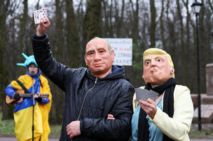 Demonstranten tragen Masken, die US-Präsident Donald Trump und seinen russischen Amtskollegen Wladimir Putin während eines Protestes vor der US-Botschaft in Kiew