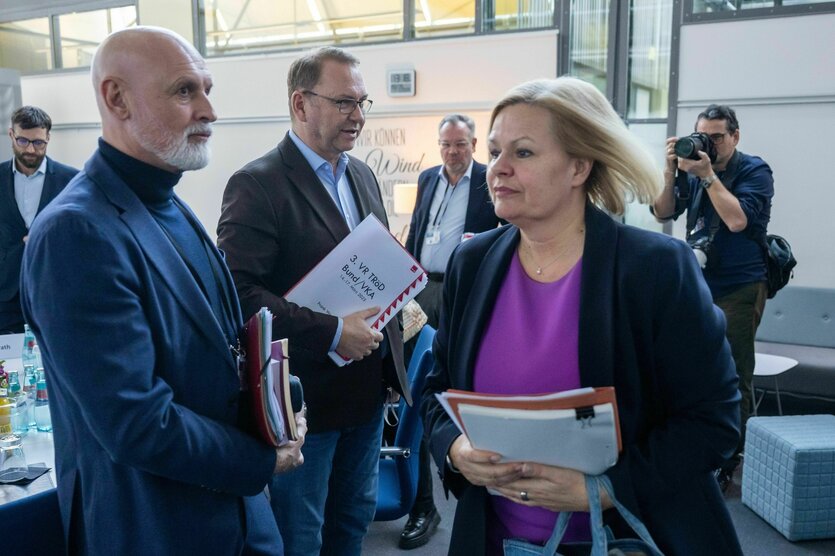 Würdigen sich keines Blickes, Nancy Faeser geht an Volker Geyer und Frank Werneke vorbei, im Hintergrund steht ein Fotograf