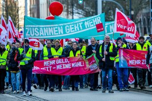 Mitglieder von Verdi mit Warnwesten und Transparenten.Sie fordern mehr Geld und mehr Zeit