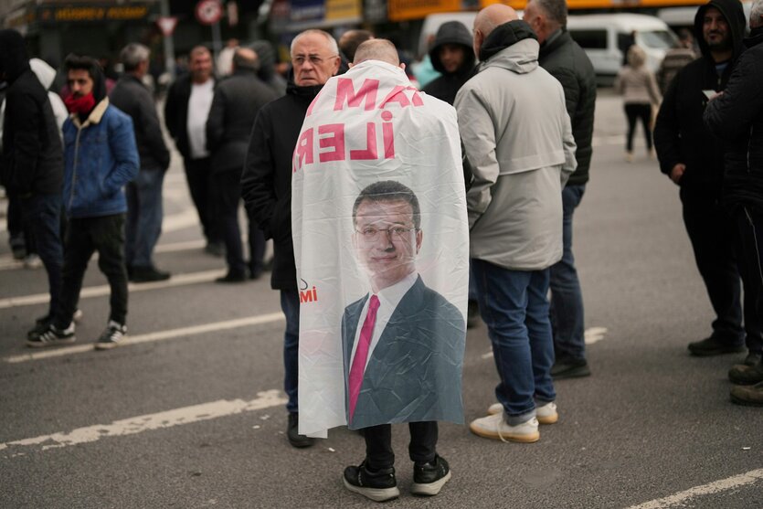 Ein Mann mit einer Fahne von Imamoglu umgehangen