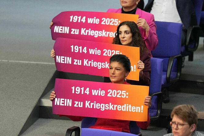 Sahra Wagenknecht und andere Mitglieder des BSW halten Schilder in der Hand: 1914 wie 2025: Nein zu Kriegskrediten !