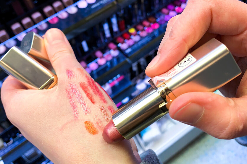 Eine Person probiert einen Lippenstift auf der Hand.