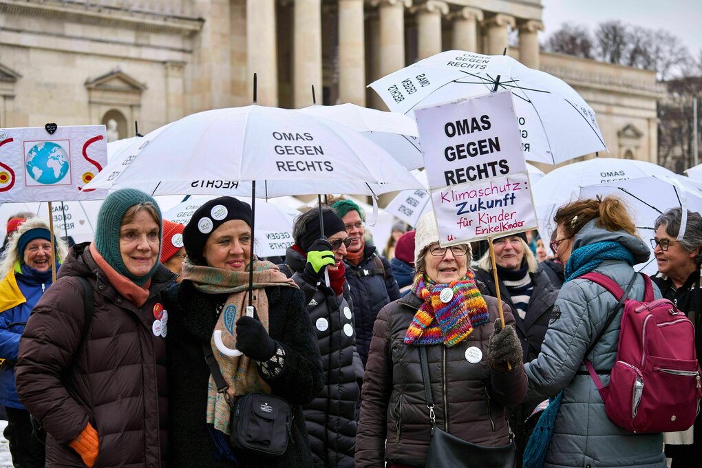 Ältere Frauen demonstrieren mit Regenschirmen und Schildern, darauf steht "Omas gegen Rechts"