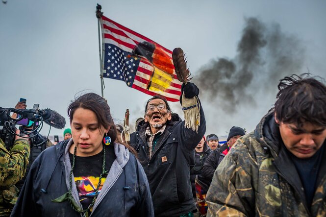 Demonstrierende mit einer bemalten US-Flagge