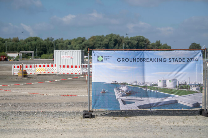 Plakat vor einer Baustelle mit der Aufschrit "Groundbreaking Stade 2024"