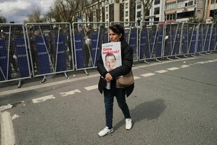 Eine Frau protestiert vor einem Aufgebot der türkischen Polizei gegen die Festnahme des Istanbuler Bügermeisters