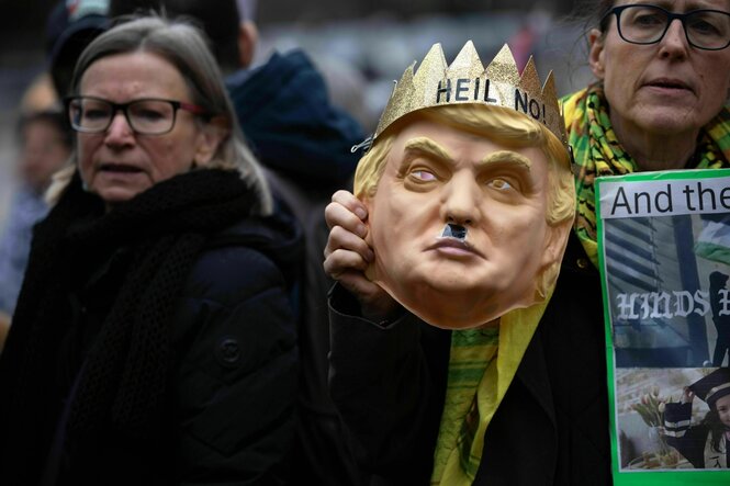 Protestaktion in New York: Eine Person hält eine Trump Gesichtsmaske hoch, die eine Krone mit der Aufschrift trägt: Heil No!