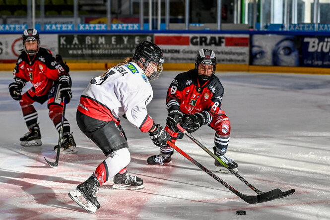 Zwei Eishockeyspielerinnen im Kampf um den Puck