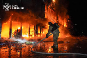 Feuerwehrmann vor einem brennden Haus