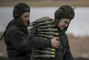 Ukrainische Soldaten tragen Munition.