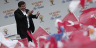 Ahmet Davutoğlu hält eine Rede, im Vordergrund türkische Flaggen.