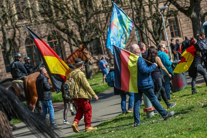 Teilnehmer eines bundesweiten Protests unter dem Motto "Gemeinsam für Deutschland? gehen mit Deutschland-Flaggen zur Demo.