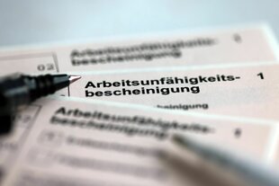 Stifte liegen auf den Arbeitsunfähigkeitsbescheinigungen