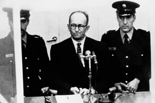 Adolf Eichmann vor Gericht, links und rechts flankiert von zwei unifomierten Männern