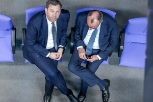 Zu sehen sind Friedrich Merz und Lars Klingbeil bei einer Absprache, von oben fotografiert, während Klingbeil hochschaut.