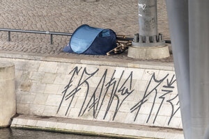 Blaues Zelt unter Brückenpfeilern