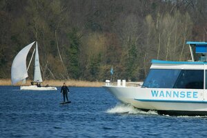 Ein Segelschiff, eine Fähre und ein Surfer auf dem Großen Wannsee.