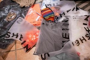 In Plastik verpackte Fast Fashion von Shein liegt auf dem Boden