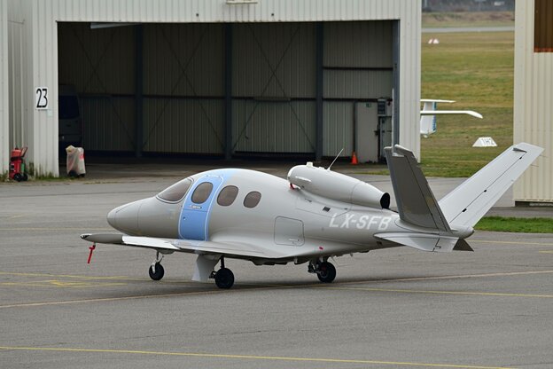 Ein kleines Flugzeug steht vor einer Flugzeughalle