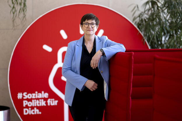 Saskia Esken steht angelehnt an rote Aufsteller