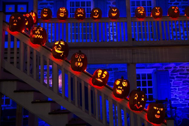 Viele erleuchtete Halloween-Kürbisse auf einer Treppe im Dunkeln