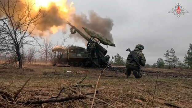 Ein Feuerball und Rauch, als eine russische Haubitze auf ukrainische Stellungen feuert