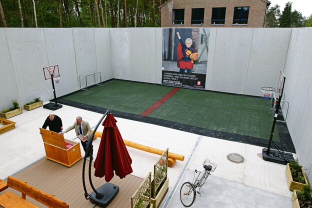 Ein Ballplatz umringt von hohen Betonmauern.
