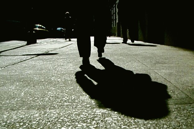 Die Beine und der Schatten einer Person von hinten.
