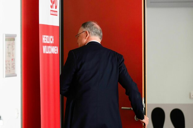Männliche Person von hinten, weg eilend, in eine rote Ecke.