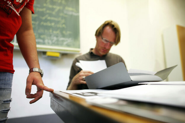 Ein Lehrer mit einem Schüler in einem Klassenraum