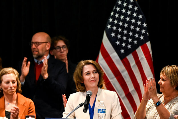 Susan Crawford steht vor einer US Flagge und wird beklatwscht