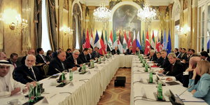 Diplomaten sitzen in Wien an einem langen Tisch.