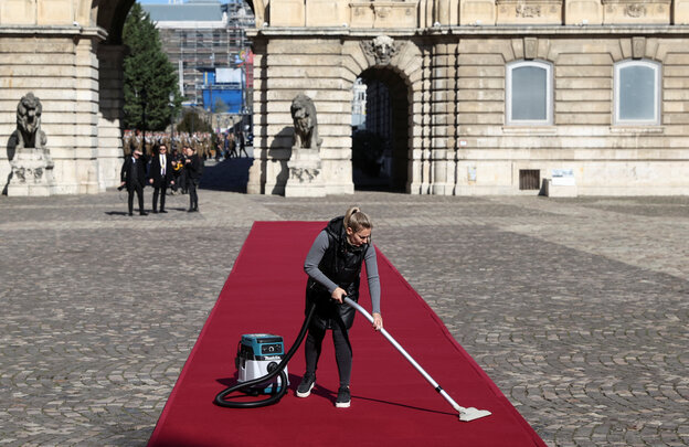 Eine Person saugt den roten Teppich