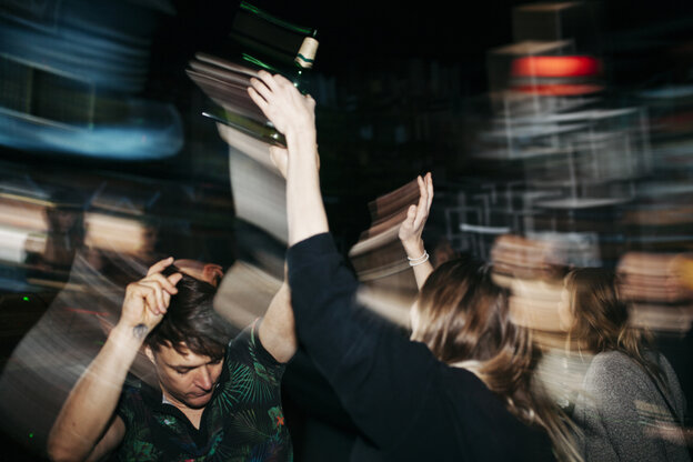Menschen tanzen und recken die Arme in die Luft