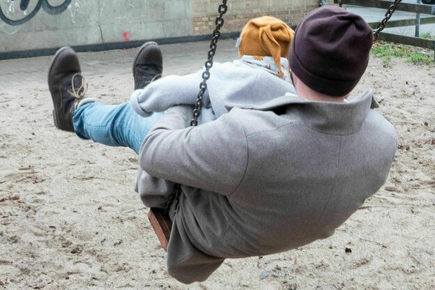 Vater mit Kind auf einer Schaukel