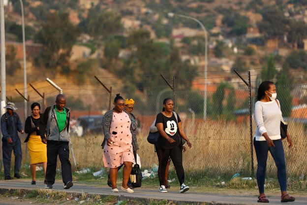 FabrikarbeiterInnen gehen in Lesotho eine Straße entlang