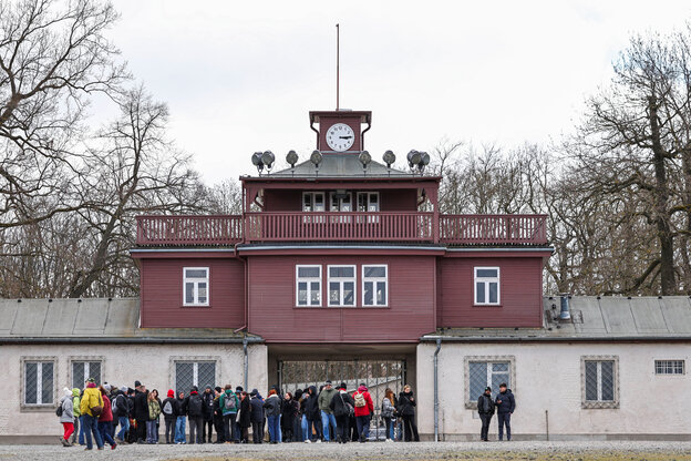 Mehrere Menschen stehen vor dem Tor des KZ Buchenwalds.